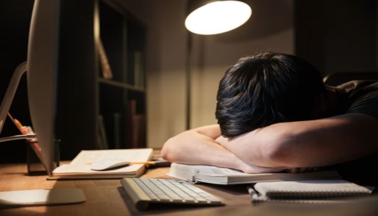 205 200054 exhausted overworked young man studying sleeping السهر يهدد تركيز طلاب الثانوية العامة السهر يهدد تركيز طلاب الثانوية العامة.. 5 نصائح لتنظيم النوم وتحسين الأداء في الامتحانات موقع في الجامعة